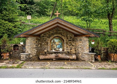 Ukraine. July 20, 2021. Roadside stone brick structure with a religious painting of jesus in front of lush green nature