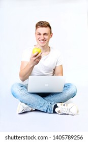 UKRAINE KHERSON APRIL 14, 2019 The Guy Is Sitting And Holding A Laptop And Eating An Apple