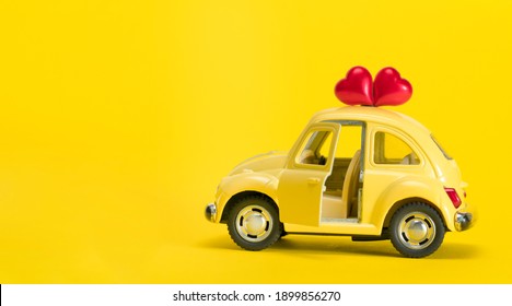 Ukraine. Kiev. 21.02.2021. View of a yellow  car with two red hearts on a yellow background Concept holiday, transport. - Shutterstock ID 1899856270