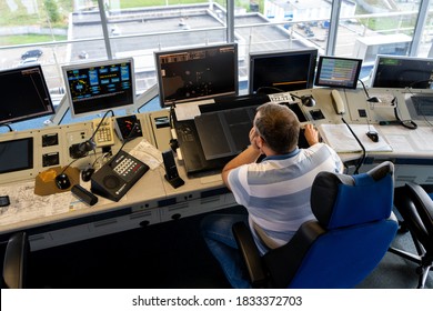 Ukraine, Kyiv - October 10, 2020: The air traffic controller at the airport manages the takeoff and landing of aircraft. Control tower inside. Flight workstation. The man looks into the monitors