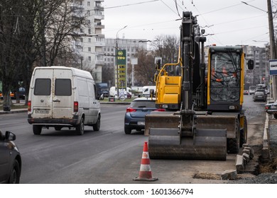 UKRAINE, LUTSK - December 1, 2019: Yellow excavator standing on a road on construction site of the road on a street. Heavy industry. Construction of a road. - Shutterstock ID 1601366794