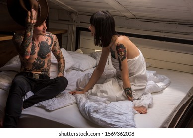 Ukraine, Lviv city, October 19, 2019, young guy and young girl with tattoo fooling on big bed in bright room  - Shutterstock ID 1569362008