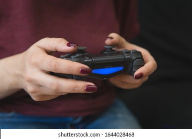 Ukraine, Odessa - July 2, 2019: A Girl Plays A Video Game On A Playstation 4 Joystick. The Ps4 Gamepad Is In The Girl’s Hands. Gamer Girl.