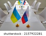 Ukraine and Russia flags on negotiation table before delegates start peace talks considering Ukrainian terms and demands to cease fire, halt aggression, stop war, end conflict and exchange prisoners