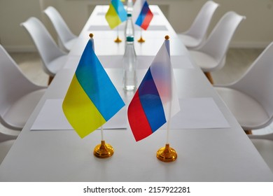 Ukraine and Russia flags on negotiation table before delegates start peace talks considering Ukrainian terms and demands to cease fire, halt aggression, stop war, end conflict and exchange prisoners - Powered by Shutterstock