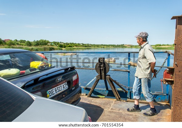Ukraine, the\
Southern Bug River - 4 June 2017: crossing. The ferry moves by the\
muscular strength of man. Repels from the steel cable. The ferryman\
moves this floating\
object.