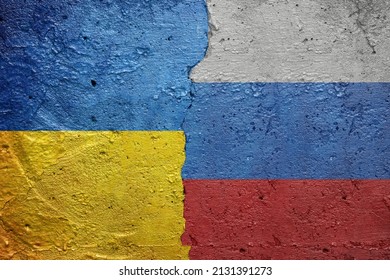 Ukraine vs Russia - Cracked concrete wall painted with a Ukrainian flag on the left and a Russian flag on the right
