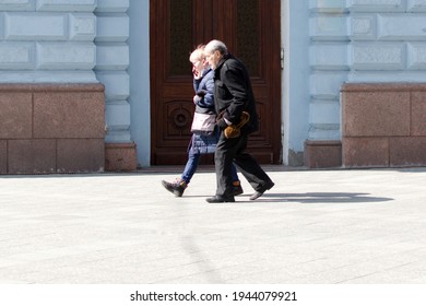 Ukraine Zhytomyr March 26, 2021. Elderly Woman And Man Walking Down The Street. Side View