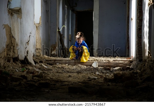 Ukrainian children in bomb shelters. The child is\
in the basement because of the war.Children against the backdrop of\
destroyed buildings due to the war.A child plays in a bomb shelter.\
War in Ukraine