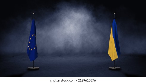 Ukrainian and European flags on supports in front of a smoky background