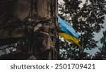 A Ukrainian flag waves in the background of war-torn ruins, captured with an artistic blur effect. The image symbolizes resilience amidst destruction during the war in Ukraine