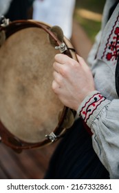 Ukrainian Folk Music, Traditional National Costume Close-up: Man's Hand In An Embroidered Shirt Linen Fabric Holds A Wooden Tambourine