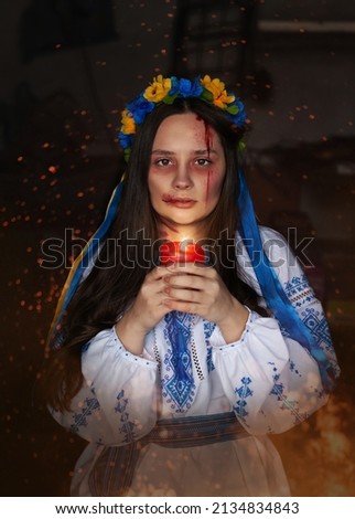 
a Ukrainian girl in Ukraine in an embroidered shirt and a national wreath with ribbons with wounds on her face in a bunker in a shelter hides from the invaders during the war with candle in fire