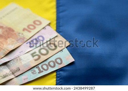 Ukrainian hryvnia of different denominations in an envelope against the background of a yellow-blue flag. copy space.