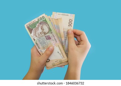 Ukrainian hryvnia in female hands isolated on a blue background. Money stack. Financial concept. A lot of 500 hryvnia banknotes. - Shutterstock ID 1846036732