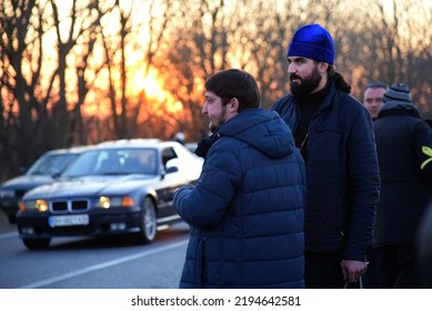 Ukrainian Orthodox Priests Watch Over A Car Convoy Of Refugees. Sunset. Second Day Of The Russian Invasion. Palanka, Odessa Region, Ukraine. February 25, 2022.