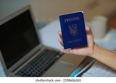 Ukrainian Passport In Hand Near The Computer