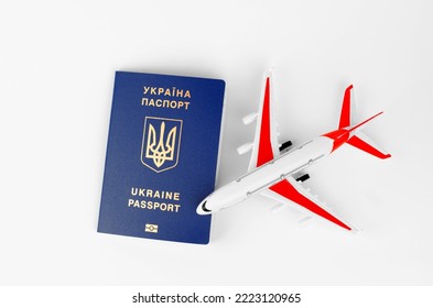 Ukrainian Passport On A White Background And A Blurry Toy Plane, Top View, Selective Focus