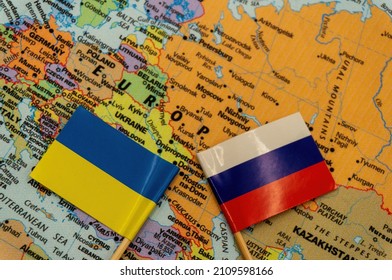 The Ukrainian and Russian flags are placed on a map of Europe.selective focus on the smaller flags top. International situation theme