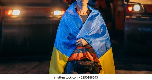 Ukrainian Smiling Young Worker With Ukrainian Flag On His Shoulders On The Background Of Road Works	
