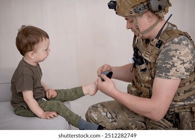 Ukrainian soldier in military uniform helps a child - Powered by Shutterstock