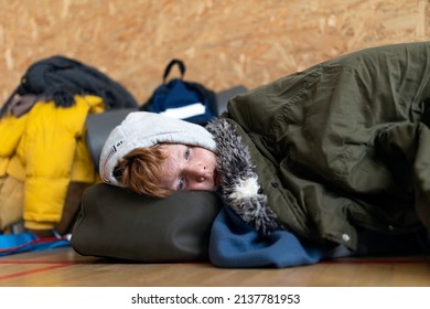Ukrainian teenage boy war refugee in temporary shelter and help center.
