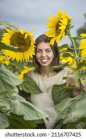 Ukrainian woman smiling beside sunflowers