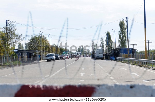 Ukrainian-Russian border. View of the border\
crossing point Kalanchak with cars inspected, people and the\
customs office – through the barbed wire. September 20, 2017.\
Khersonskaya oblast,\
Ukraine