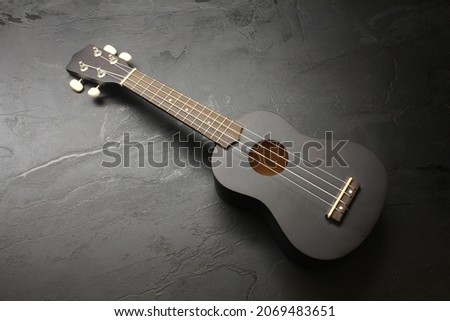 An ukulele on a dark surface