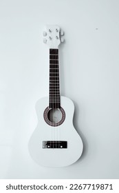 The ukulele is a small guitar-like stringed instrument, about 20 inches, and is a native Hawaiian musical instrument. 
				ukulele on a white background