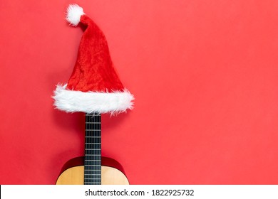 Ukulele Wearing A Santa Claus Hat. Christmas Songs. New Year's Concert. Hawaiian Music. Christmas Musical Flat Lay With Copy Space. Concert Invitation