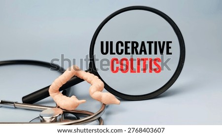 Ulcerative Colitis Text Seen Through Magnifying Glass with Colon Model and Stethoscope on Blue Background for Gastrointestinal Diagnosis. 