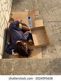 Ulcinj Montenegro-July 2021: Refugee Man Sleeping In A Cardboard Box On A City Street.