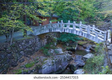 Ulsan, South Korea - October 22nd, 2023: A traditional stone bridge spans a serene creek in Seoknamsa Valley near Seoknamsa Temple, surrounded by lush greenery and natural rock formations. - Powered by Shutterstock