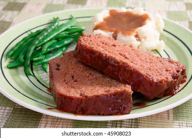 The Ultimate Comfort Food - Meat Loaf Prepared With Ground Beef, Grated Carrots, Bread Crumbs, And Herbs And Spices. Served With Fresh Green Beans, Mashed Potatoes, And Gravy.