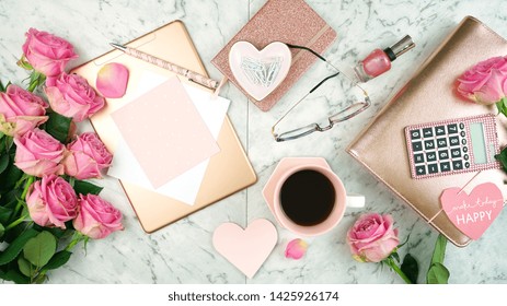 Ultra Feminine Pink Desk Workspace With Rose Gold Accessories On White Marble Background Flatlay Overhead.