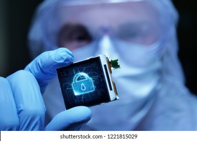 In Ultra Modern Electronic Manufacturing Factory Design Engineer in Sterile Coverall Holds Microchip with symbols in futuristic holography. internet security system.
