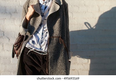 Ultra-fashion Concept. Young Woman Of Fashion Wearing Gray Coat And Posing Over White Background. Street Style. Businesswoman. Outdoors. Fashionable Accessories.