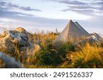 Ultralight tent for solo travel. Wild camping at mountain peak during hiking in nature. Outdoors adventure