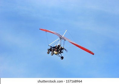 Ultralight trike flying with a pilot and a passenger