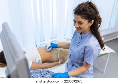 Ultrasound diagnostic of stomach on abdominal to woman in clinic, closeup view. Doctor runs ultrasound sensor over patient's girl tummy and looks at image on screen. Diagnosis of internal organs. - Shutterstock ID 2233892073