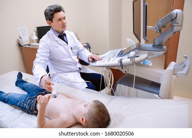 Ultrasound examination of the child. The doctor makes an abdominal scan of a boy in a medical clinic.