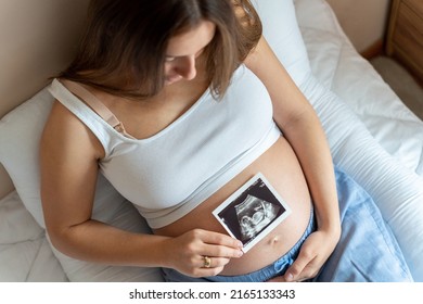 Ultrasound image pregnant baby photo. Woman holding ultrasound pregnancy picture. Pregnancy, medicine, pharmaceutics, health care and people concept - Powered by Shutterstock