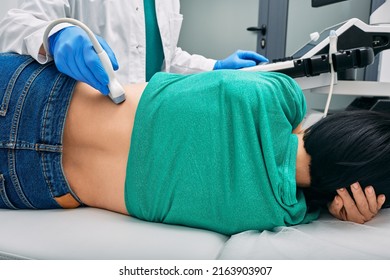 Ultrasound of kidneys. Woman patient during ultrasound examination in medical clinic lying on side, view from back - Shutterstock ID 2163903907