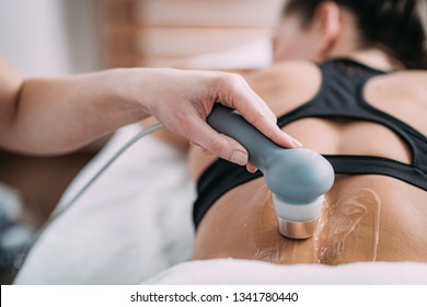 Ultrasound In Physical Therapy. Therapist Using Ultrasound Applicator On A Patient’s Lower Back