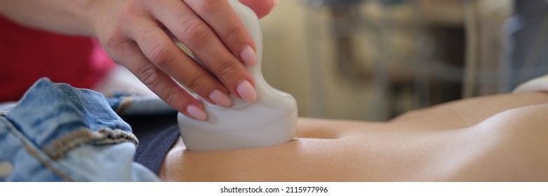 Ultrasound Scanner In Hands Of Doctor Examines Woman Pelvis. Pregnancy Diagnosis Concept