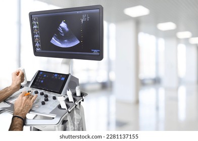 Ultrasound or sonogram procedure. Doctor hand holding an ultrasound sensor. Ultrasound examination.Screen of an ultrasound machine with a heart image.