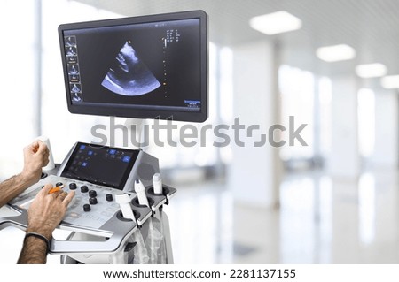 Ultrasound or sonogram procedure. Doctor hand holding an ultrasound sensor. Ultrasound examination.Screen of an ultrasound machine with a heart image.