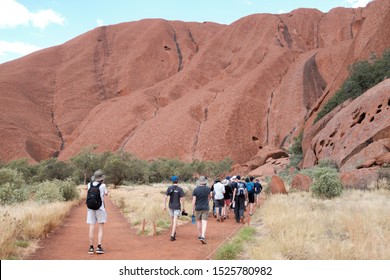 ULURU AYRES ROCK, NT/AUSTRALIA - APRIL, 2019. Walkers Set Off On A Guided Tour Around The Base Of Uluru Formerly Known As Ayres Rock.