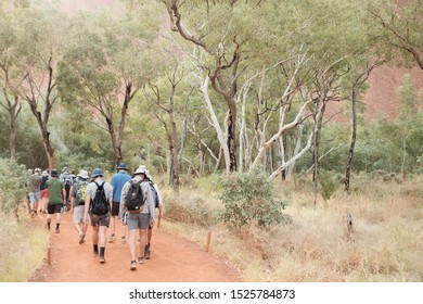 ULURU AYRES ROCK, NT/AUSTRALIA - APRIL, 2018. Walkers Continue Their Guided Tour Around The Base Of Uluru Formerly Known As Ayres Rock.